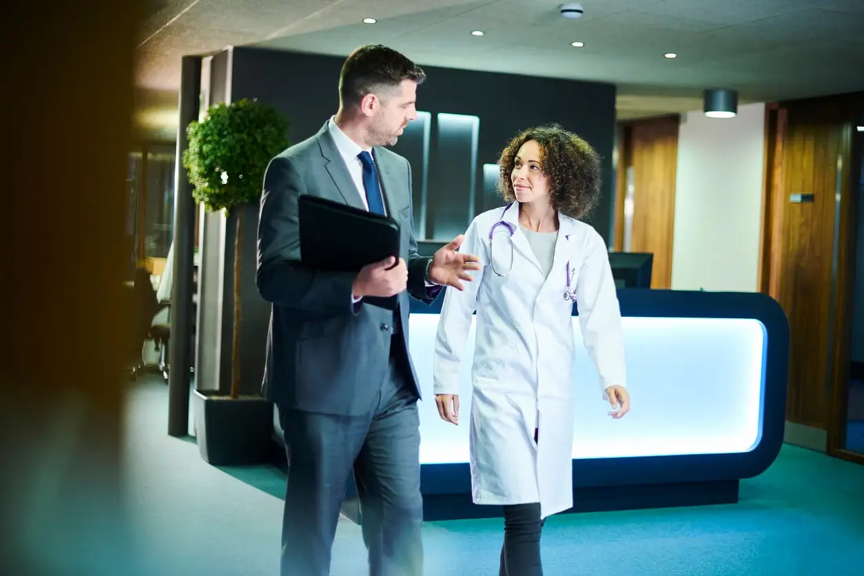 A man in a suit talking to a female doctor